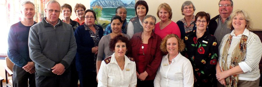 â€˜n Deel van die Hospice seminaar-gangers in Herberg-aan-See se sitkamer, met voor die seminaar-aanbieders, Suster Gerna van der Riet en Fransil Kotze